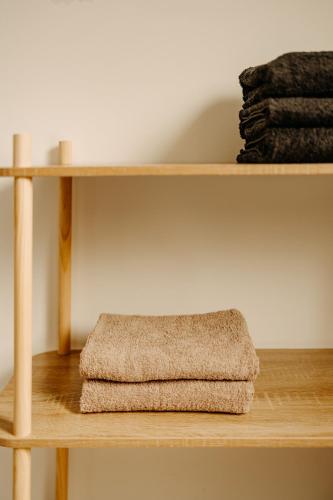 une étagère en bois avec une serviette dessus dans l'établissement Le Carpe Diem, à Fiquefleur-Équainville