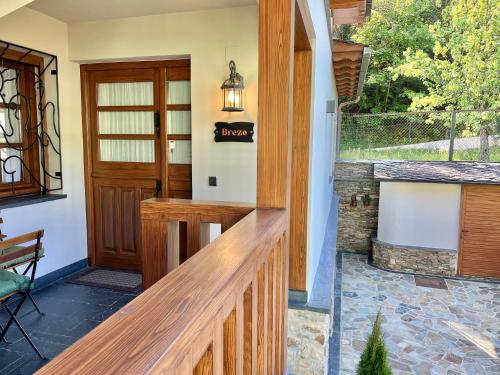 a front porch with a wooden railing and a door at Fuentes del Narcea apartamentos rurales in Cangas del Narcea