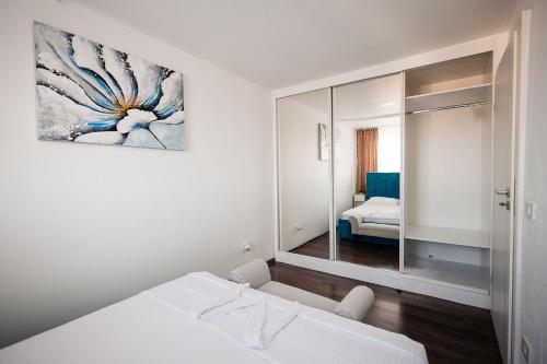 a white room with a bed and a mirror at MM Modern in Alba Iulia