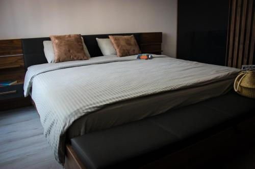 una camera da letto con un letto grande con lenzuola bianche di Sea Shine Apartament, frontal sea view a Mamaia Nord - Năvodari