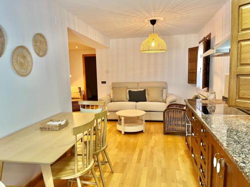 a kitchen and living room with a couch and a table at Fuentes del Narcea apartamentos rurales in Cangas del Narcea