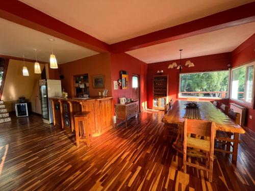 sala de estar con mesa de madera y cocina en Buena Vida Social Club, en El Bolsón
