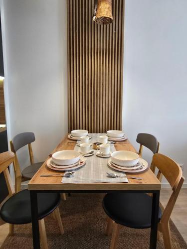 a wooden table with chairs and plates on it at Jetsetters Corner Near Airport in Sarajevo