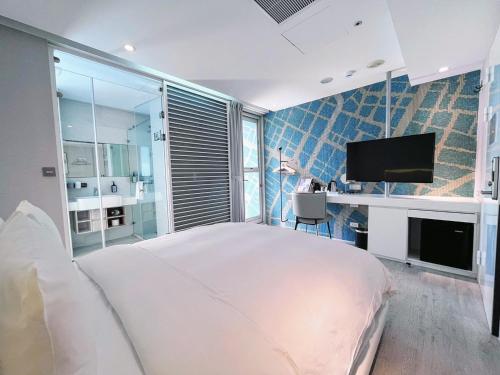 a bedroom with a bed and a desk and a tv at Hotel Mapp in Taichung