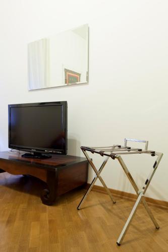a flat screen tv sitting on top of a wooden table at Exclusive Aparthotel La Reunion in Ravenna