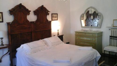 um quarto com uma grande cama de madeira e uma cómoda em B&B La casa del mugnaio di Capriata d'Orba em Predosa