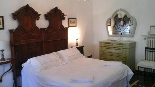 a bedroom with a large wooden bed and a dresser at B&B La casa del mugnaio di Capriata d'Orba in Predosa