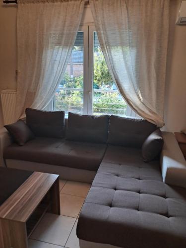 a living room with a couch and a window at Epanomi apartment in Epanomi