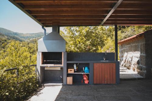 a outdoor kitchen with a stove in a building at Casa da Mouta - Douro Valley in Baião
