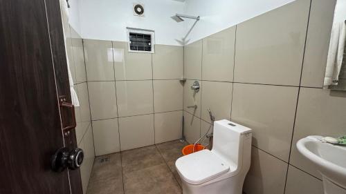 a small bathroom with a toilet and a sink at beehive Villa in Padinjarathara
