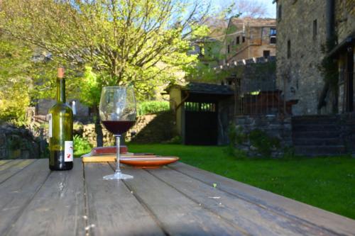 a glass of wine sitting on a wooden table at Casa Rural Calzon Ordesa in Oto