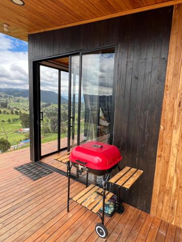 a red stool on the deck of a house at Cabañas Finca La Ponderosa in Zipaquirá