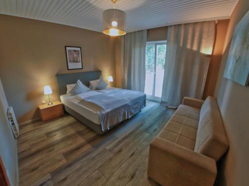 a bedroom with a bed and a couch at Haus im Park in Sankt Kanzian