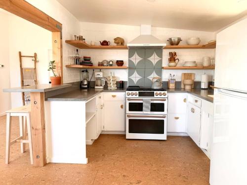 a kitchen with white cabinets and a stove top oven at Joshua Tree - Under the Stars-Pool, Spa & Fire pit in Yucca Valley