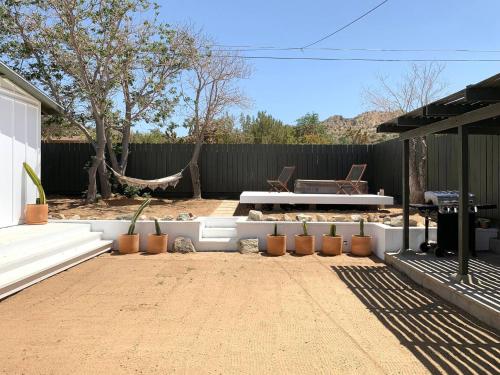 a backyard with a bench and a table and a fence at Joshua Tree - Under the Stars-Pool, Spa & Fire pit in Yucca Valley