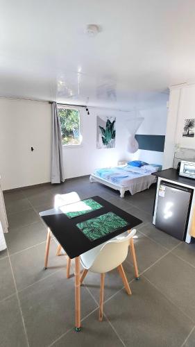 a living room with a table and a bed at Palm Activity in Saint-Pierre