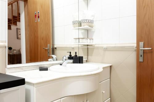 a white bathroom with a sink and a mirror at Casa Borda da Rocha in Nordeste