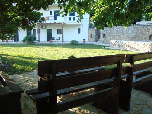 a wooden bench sitting in front of a house at Kourtis in Paramythia