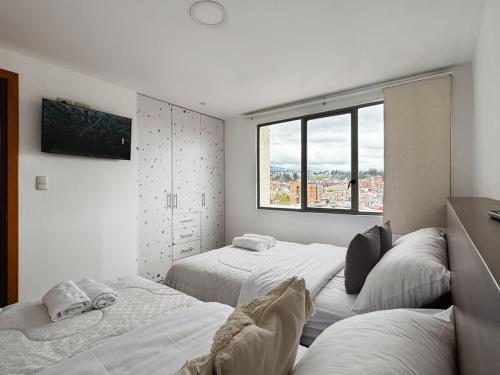 Un dormitorio con tres camas y una ventana. en Magical Viewpoint For Families and Groups for 8 person, en Cuenca