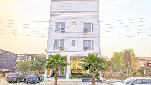 a white building with palm trees in front of it at HOTEL GREEN VEGAS in New Delhi