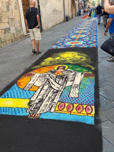 a street with a painting of a woman on the sidewalk at L'ARCO E' DI FIO in Camaiore