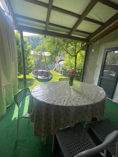 a table and chairs on a porch with a swing at Чотири стихії in Mizhhirʼʼya