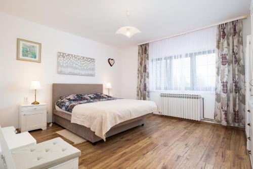 a white bedroom with a bed and a window at Monte Petrus in Vujci