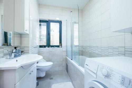 a white bathroom with a toilet sink and a shower at Monte Petrus in Vujci