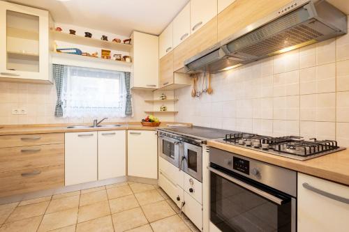 a kitchen with white cabinets and a stove top oven at Monte Petrus in Vujci
