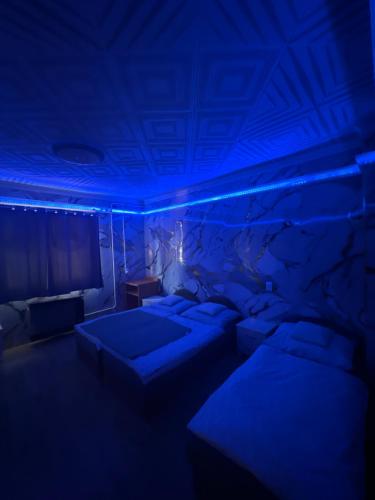 a room with two beds and a blue ceiling at Balika vendégház in Tiszaújváros
