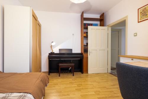 a bedroom with a desk and a piano in a room at Monte Petrus in Vujci