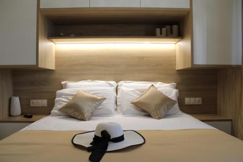 a hat sitting on top of a bed with pillows at Comfy Apartments Center in Nikiti