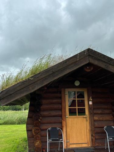 a log cabin with two chairs and a door at Kuningatalu camping in Võru