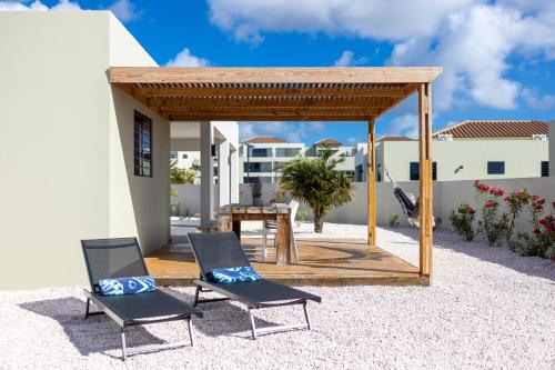 a gazebo with two chairs and a table at Villa Monrel Mambo Beach in Willemstad