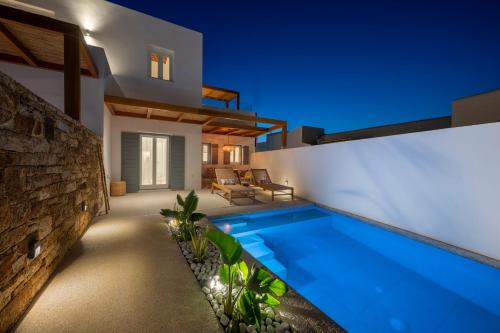 a villa with a swimming pool at night at Ios Art Suites in Ios Chora