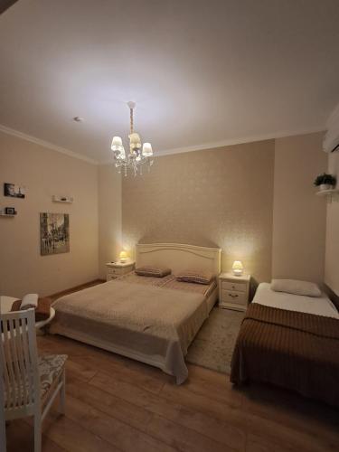 a bedroom with two beds and a chandelier at Apartment on Sumskaya 46 "Central Residence" in Kharkiv