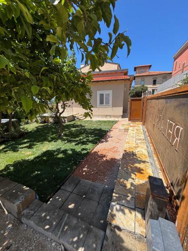 a walkway leading to a yard with a fence at Relais dei Molini - Villa dei Molini in Castagneto Carducci