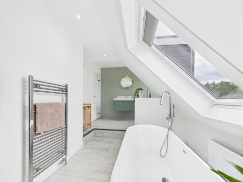 a white bathroom with a sink and a window at Priestrig Cottage in Hawick