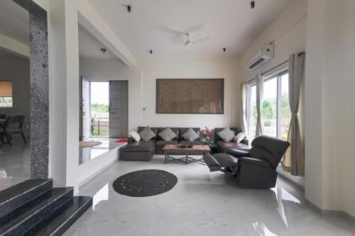 a living room with a couch and chairs at River bloom escape in Karjat