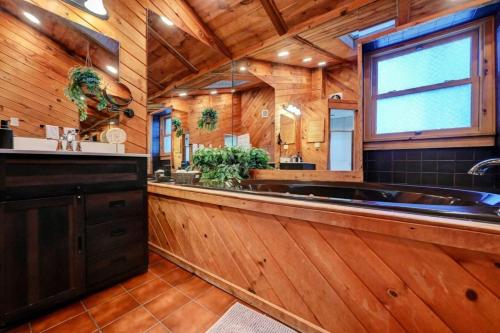 une grande salle de bain avec une grande baignoire et des murs en bois dans l'établissement Cozy mountain house with beach access and firepit, à Lake Harmony