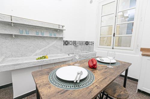 ジェノヴァにあるiFlat Historical Luxury Apartment San Luca 11 Bのキッチン(木製テーブル、ワイングラス付)
