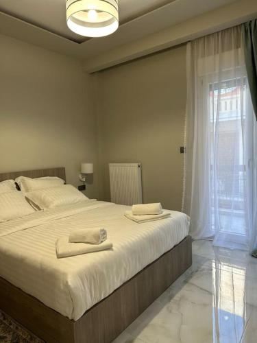 a bedroom with a large bed with two towels on it at A living skg 1 Quiet Luxury in Thessaloniki