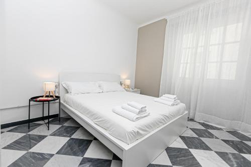 ジェノヴァにあるiFlat Historical Luxury Apartment San Luca 11 Bの白いベッドルーム(タオル付きのベッド付)