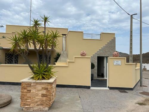 una casa amarilla con palmeras delante en Casa La Pita, en El Pozo de los Frailes
