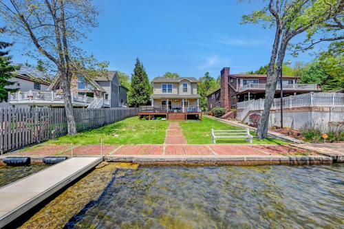 a home with a pond in front of a house at Lakefront home with kayaks fire pit hot tub and walk to restaurants and bars in Lake Harmony