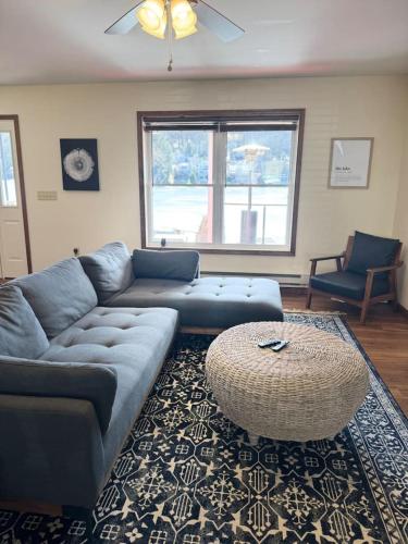 a living room with a couch and a table at Lakefront home with kayaks fire pit hot tub and walk to restaurants and bars in Lake Harmony