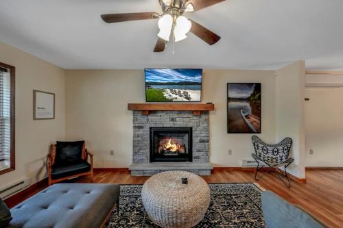 a living room with a fireplace and a couch at Lakefront home with kayaks fire pit hot tub and walk to restaurants and bars in Lake Harmony