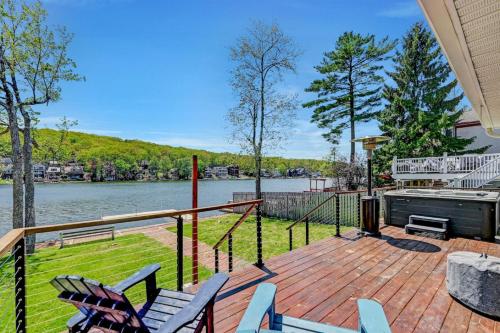 a deck with chairs and a view of the water at Lakefront home with kayaks fire pit hot tub and walk to restaurants and bars in Lake Harmony