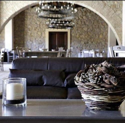 un soggiorno con divano e tavolo con candela di Fontana Murata Resort & spa a Borgo Regalmici