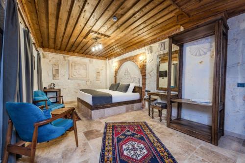 a bedroom with a bed and a chair and a table at Soho Cappadocia in Goreme